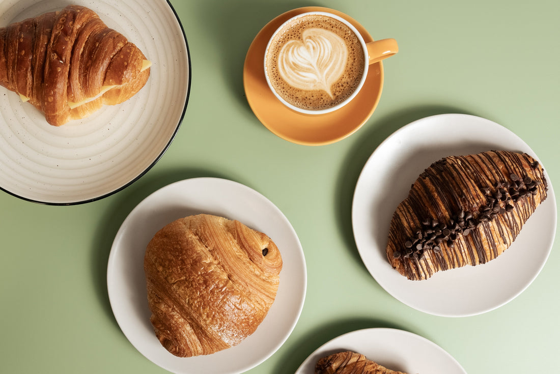 A green table showing a plated selection of pastries and coffee available from Canterbury Bakery