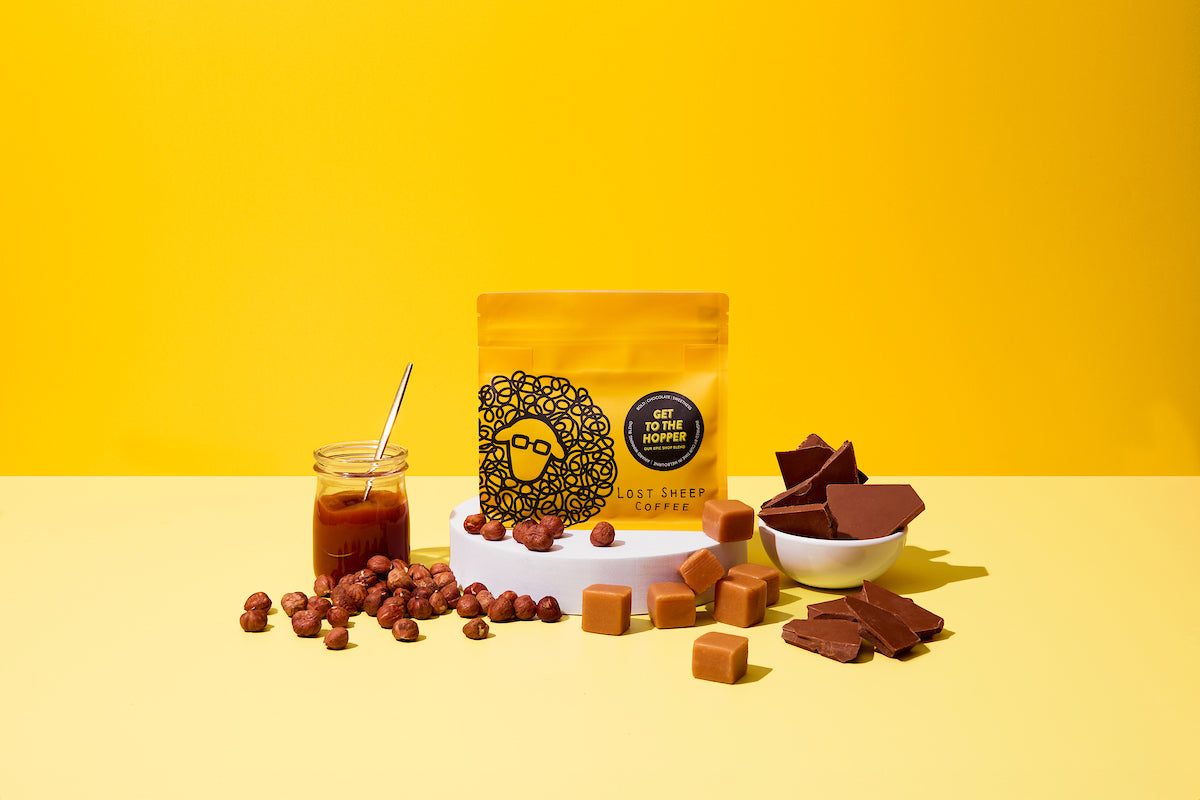 Lost Sheep Coffee's Epic Shop Blend in yellow packaging surrounded by Caramel, hazelnuts, fudge and milk chocolate tasting notes